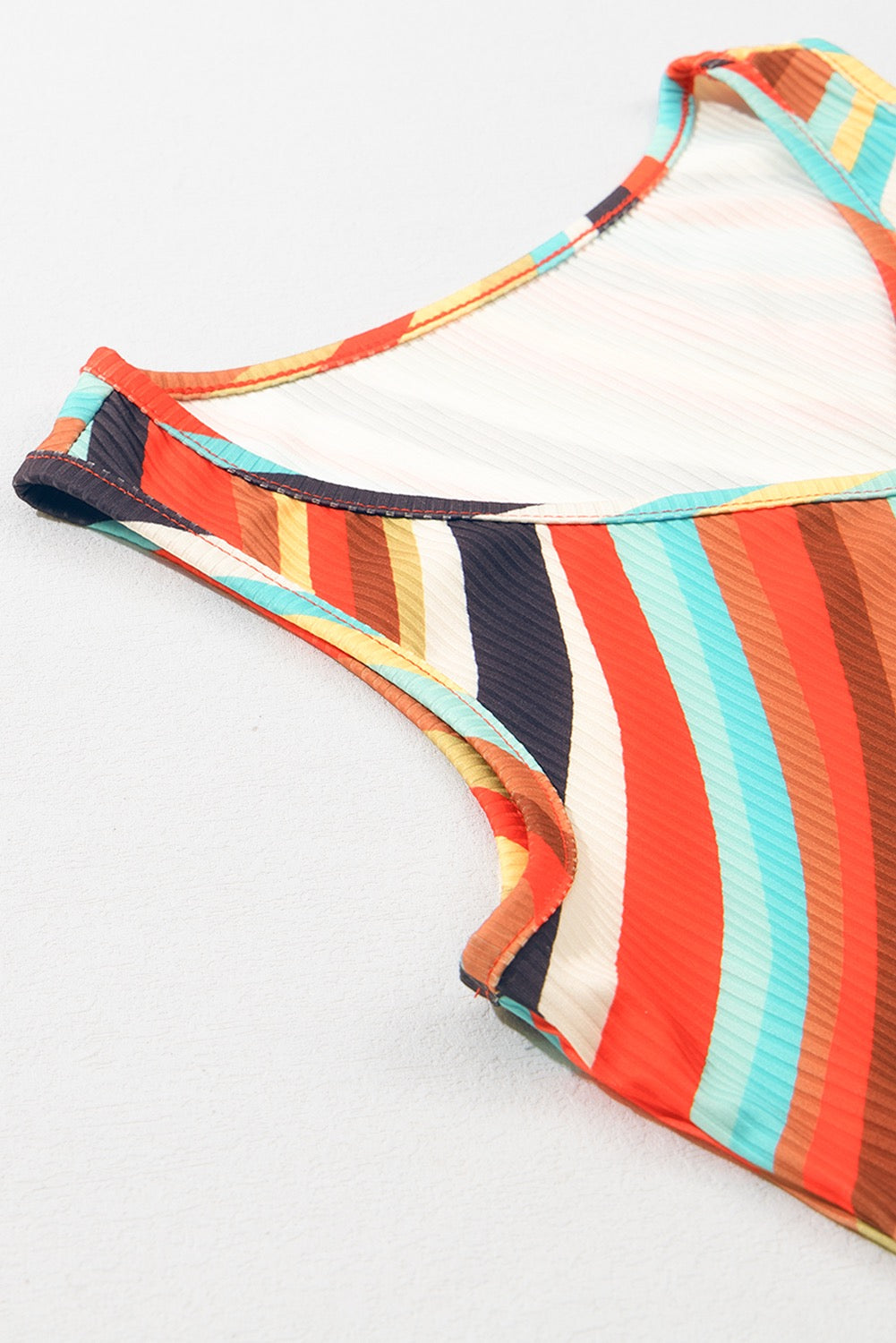 Multicolored striped bikini top on a white background