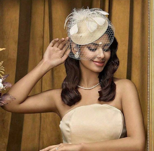 Woman wearing a beige dress and decorative headpiece with a veil 