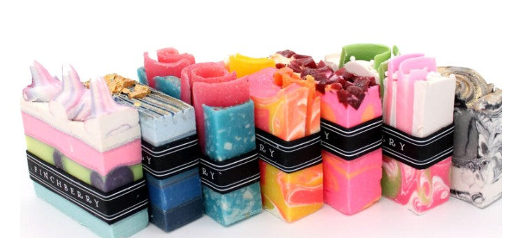 Assorted colorful soap bars with visible brand name on a white background