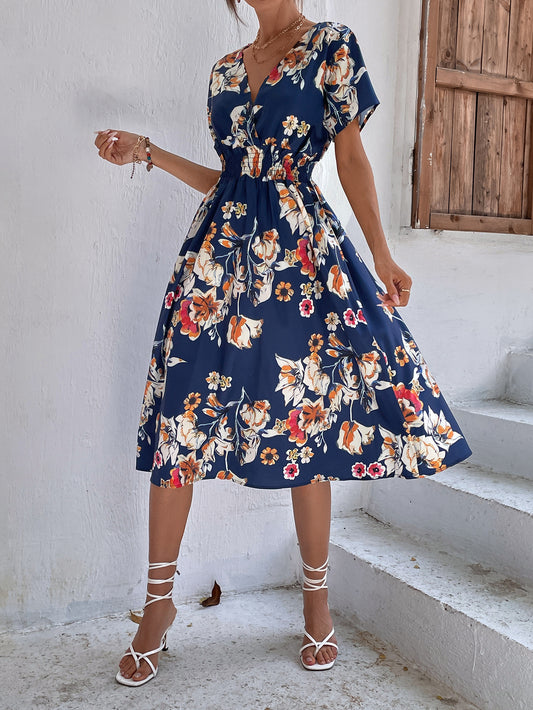 Woman wearing navy floral A-line midi dress with white heels