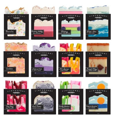 Grid of hand-crafted soaps packaging with various scents and colors.